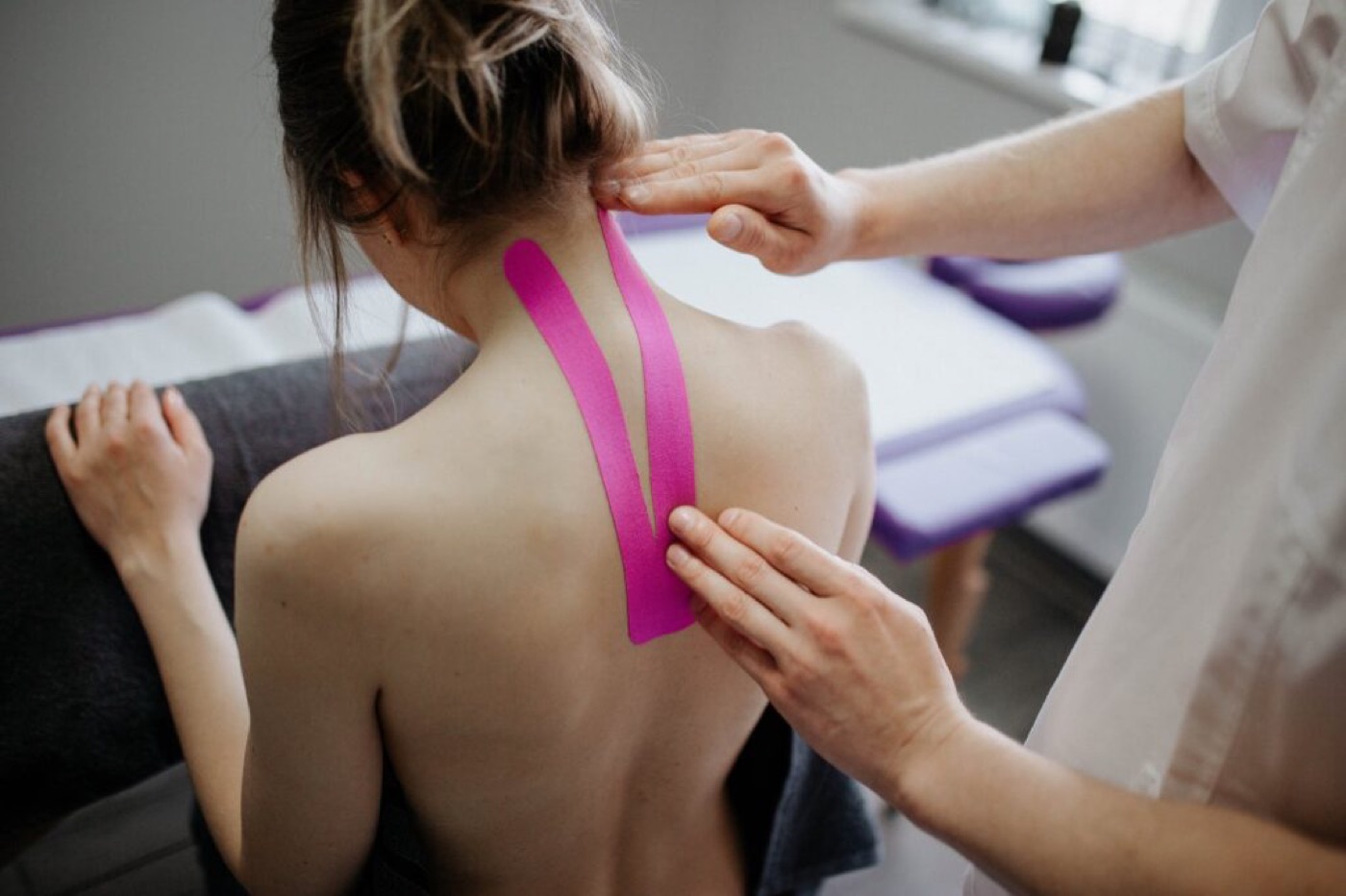 person making taping to woman s neck