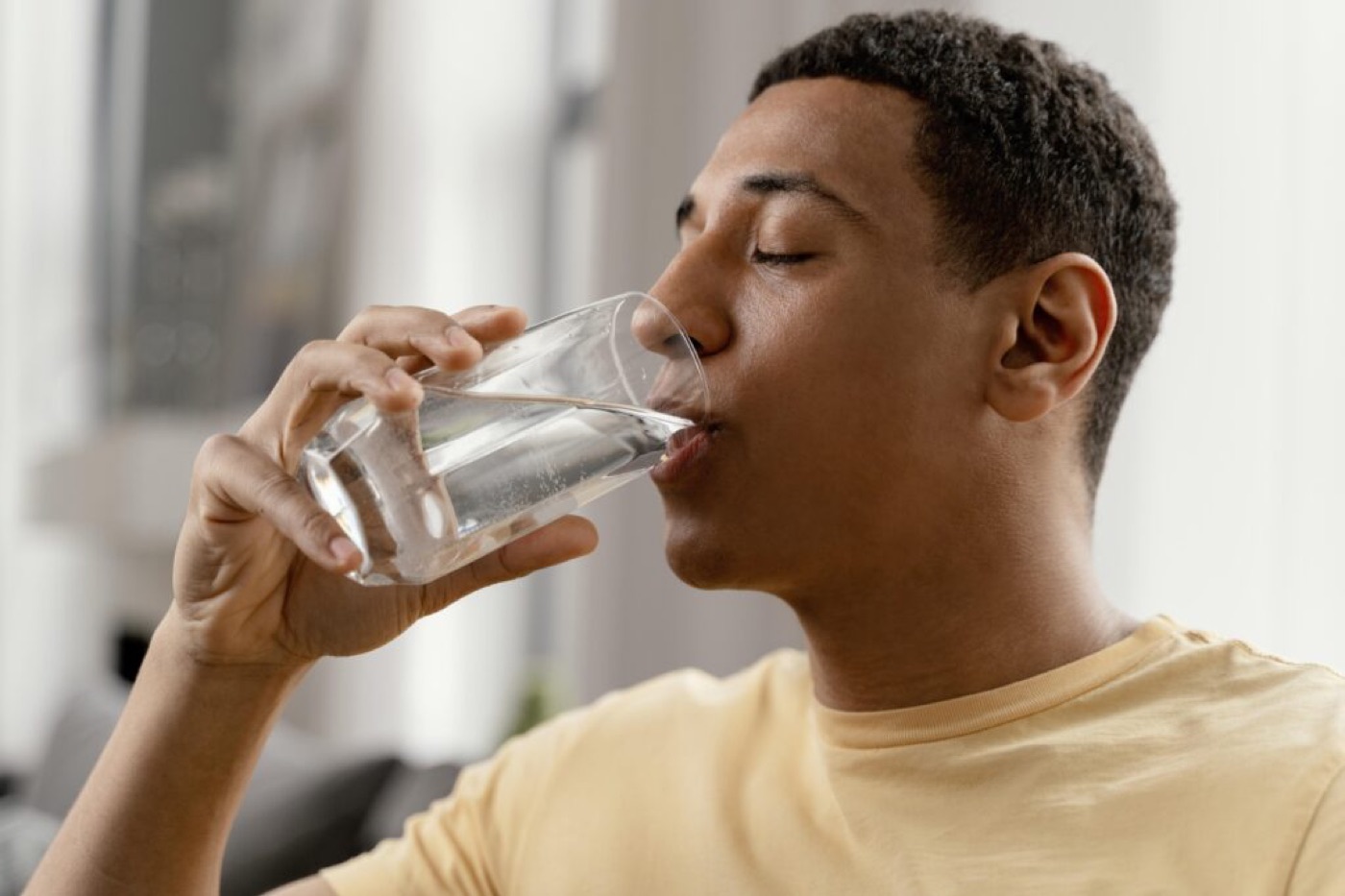 Man drinking a glass of water at home
